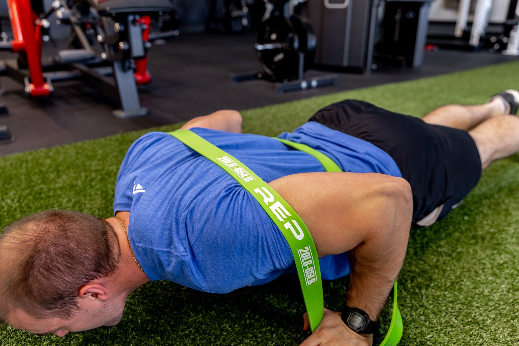Athlete using a green Latex-Free Pull-Up Band for assistance while performing push-ups.
